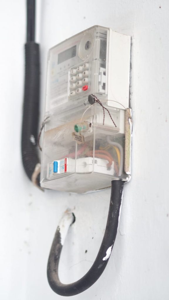 Petugas PLN memeriksa meteran listrik di salah satu rumah warga.