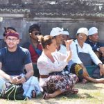 Wisatawan mengenakan busana adat Bali saat berada di dalam pura.