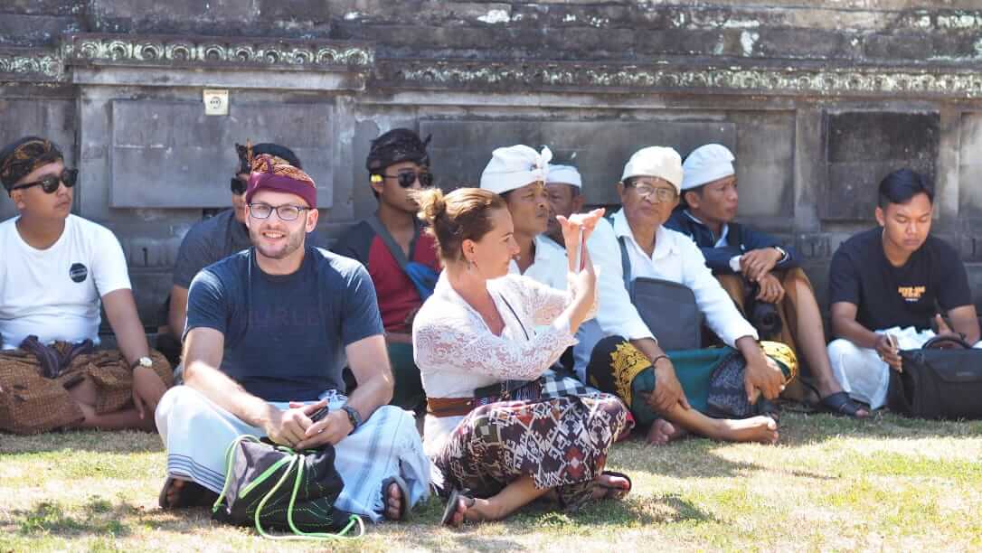 Wisatawan mengenakan busana adat Bali saat berada di dalam pura.