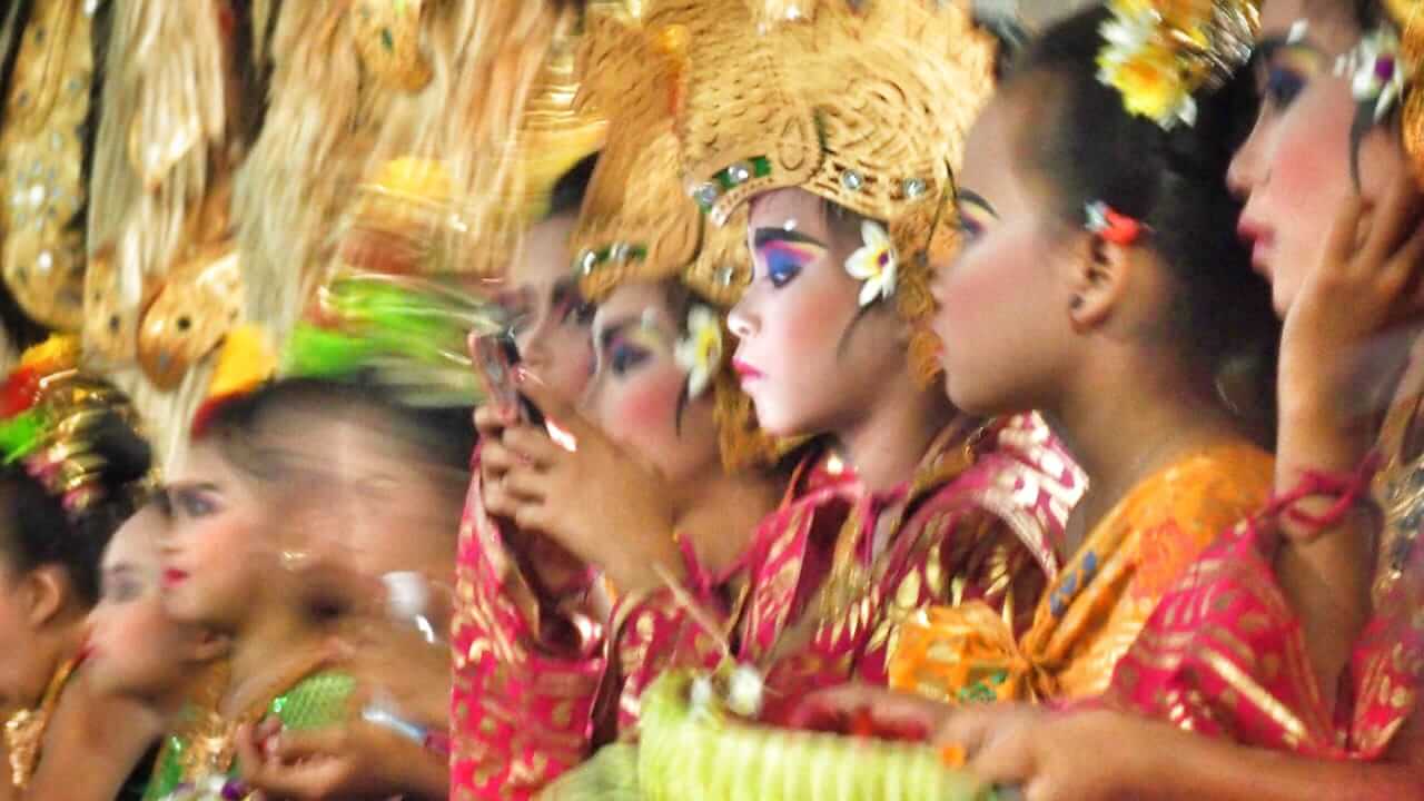 Sekelompok anak-anak penari Bali bersiap menari dengan busana adat, menggambarkan pelestarian tradisi melalui generasi muda.