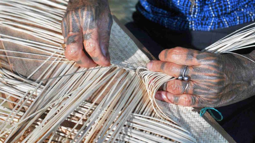 Seorang pengrajin mengerjakan anyaman tradisional sebagai bagian dari warisan budaya.