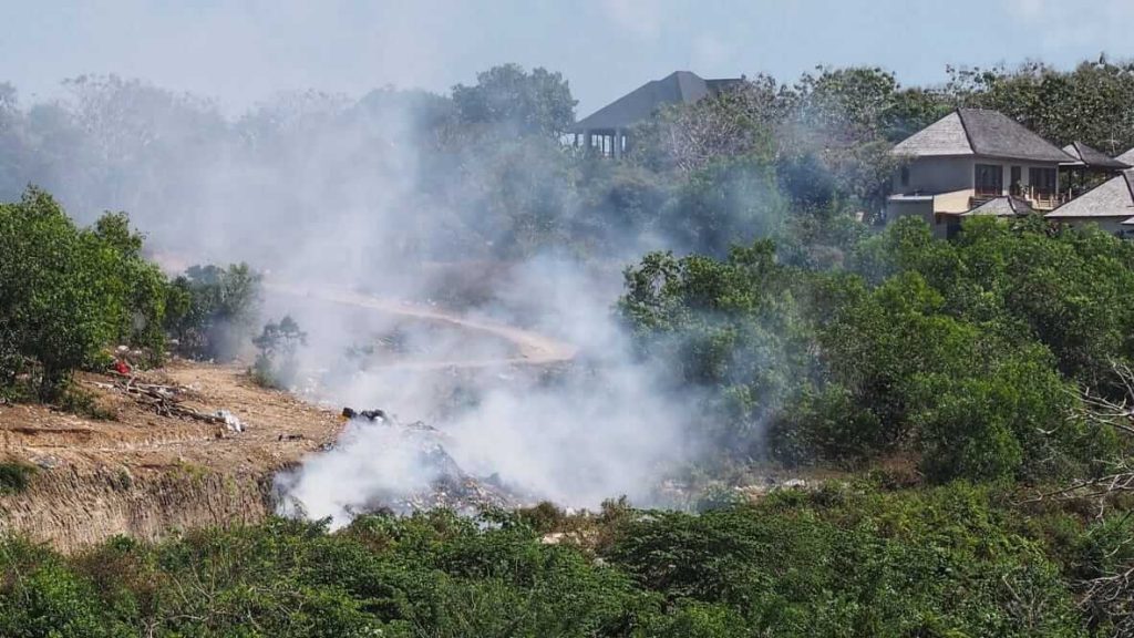 Asap tebal membubung dari tumpukan sampah yang dibakar di Bali, menunjukkan permasalahan pengelolaan limbah yang belum tertangani dengan baik.