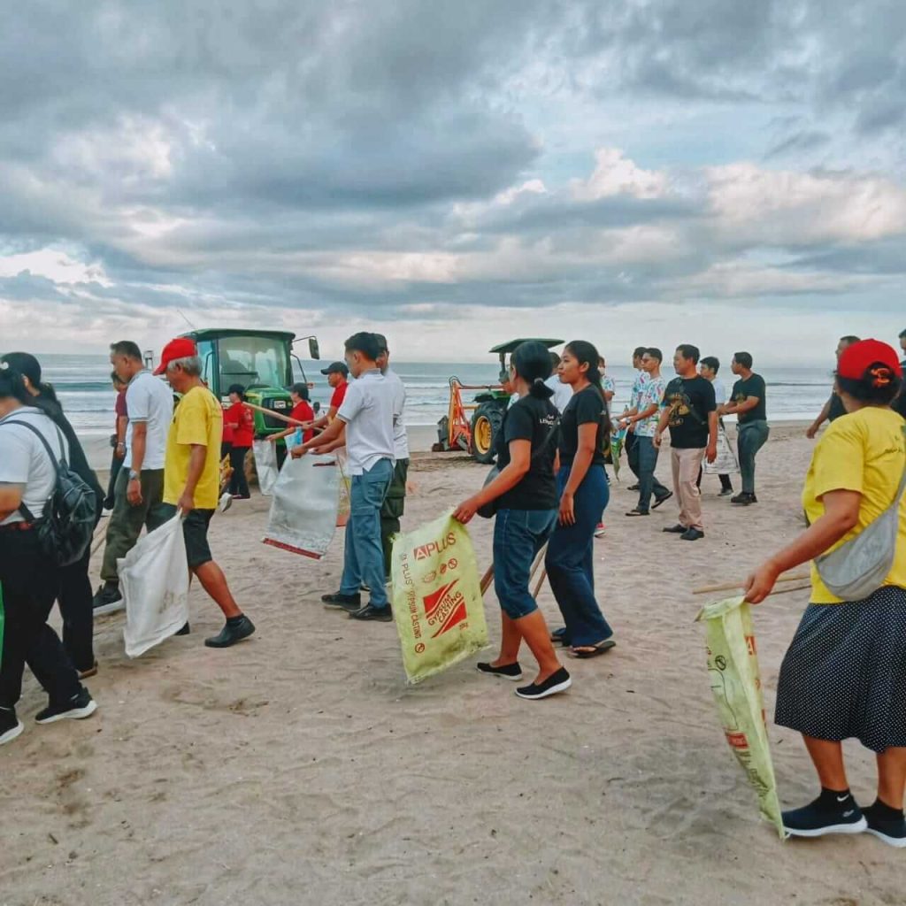 Relawan BumiKita dan staf Bintang Bali Resort bekerja sama membersihkan sampah di Pantai Kuta.