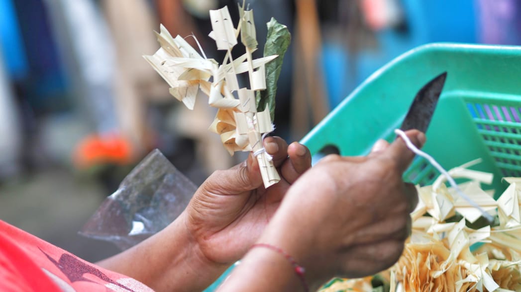 Ibu Putu Murni merangkai sarana banten sebagai persiapan Hari Raya Galungan.