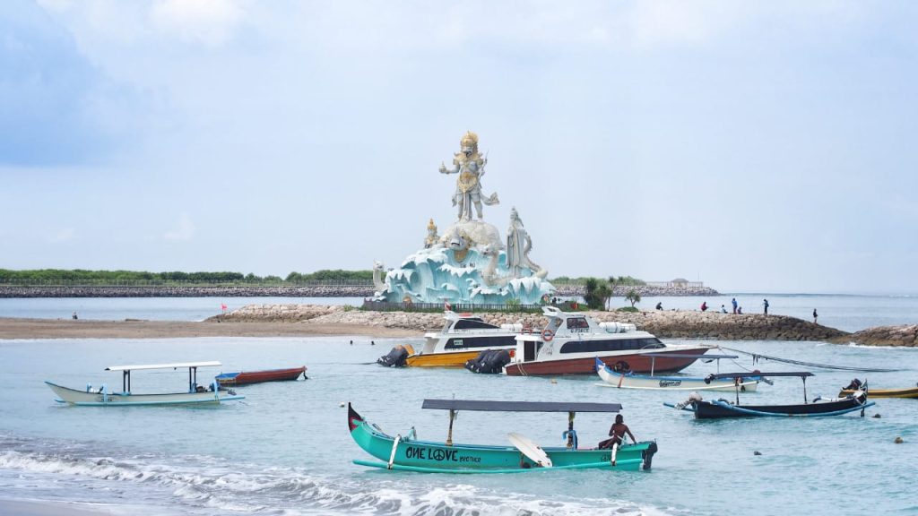 Pemandangan Pantai Jerman dengan garis pantai yang landai dan pesawat yang tampak melintas rendah di kejauhan.