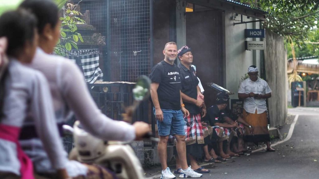 Seorang pecalang Bali berdiri menjaga area upacara adat.