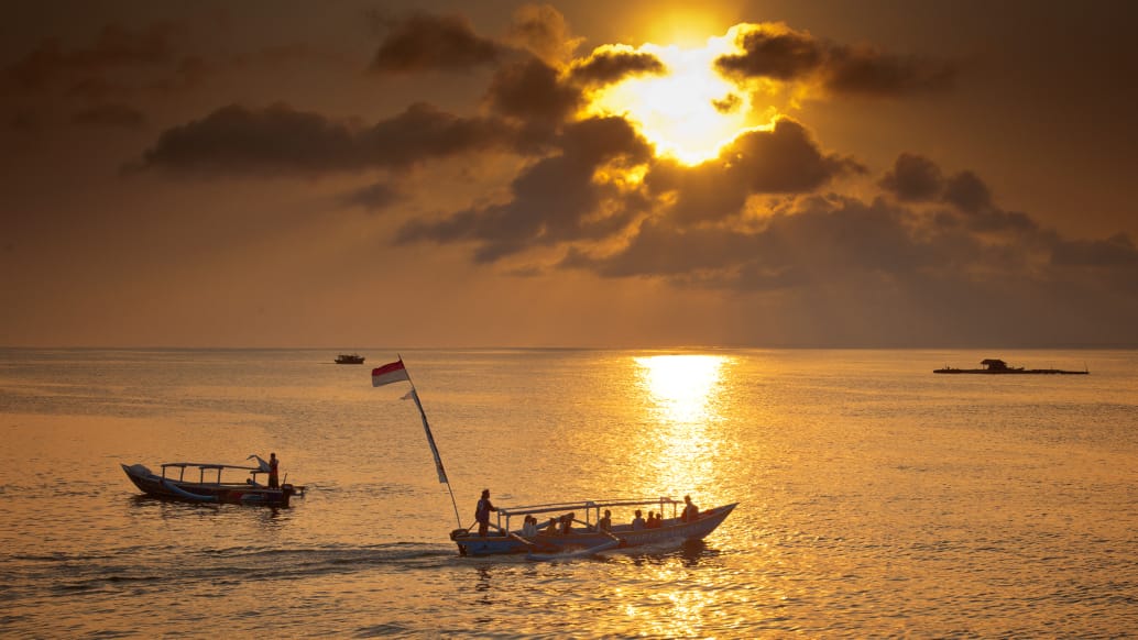 Siluet seseorang berjalan di jalan sepi saat matahari terbenam, menggambarkan perjalanan hidup dan refleksi diri.