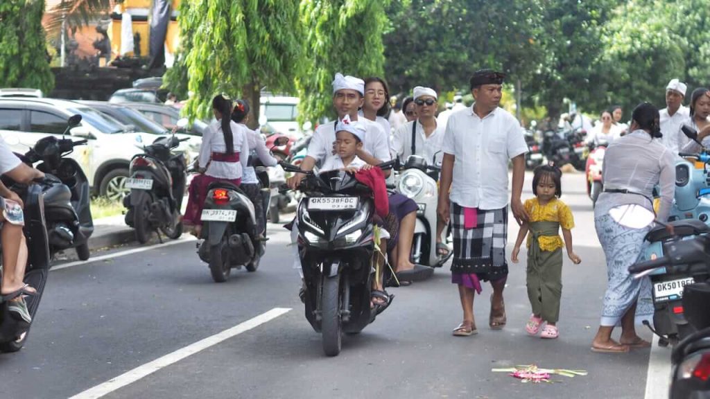 Warga Bali mengenakan busana adat, berjalan menuju pura dan tempat suci keluarga untuk melaksanakan sembahyang pada Hari Raya Kuningan.