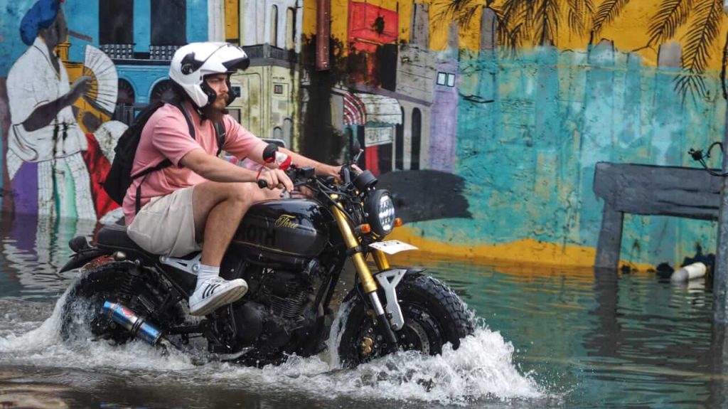 Banjir menggenangi Jalan Dewi Sri Bali, warga dan pengendara tetap melintas meski jalan tergenang.
