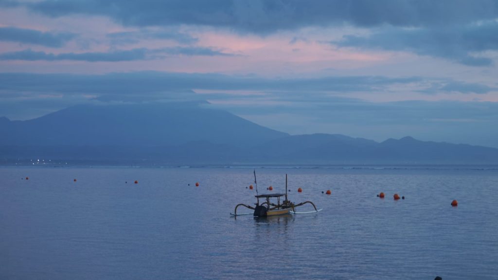 Panorama sunrise di Pantai Duyung dengan cahaya matahari muncul dari horizon, terlihat pengunjung menikmati suasana pagi.