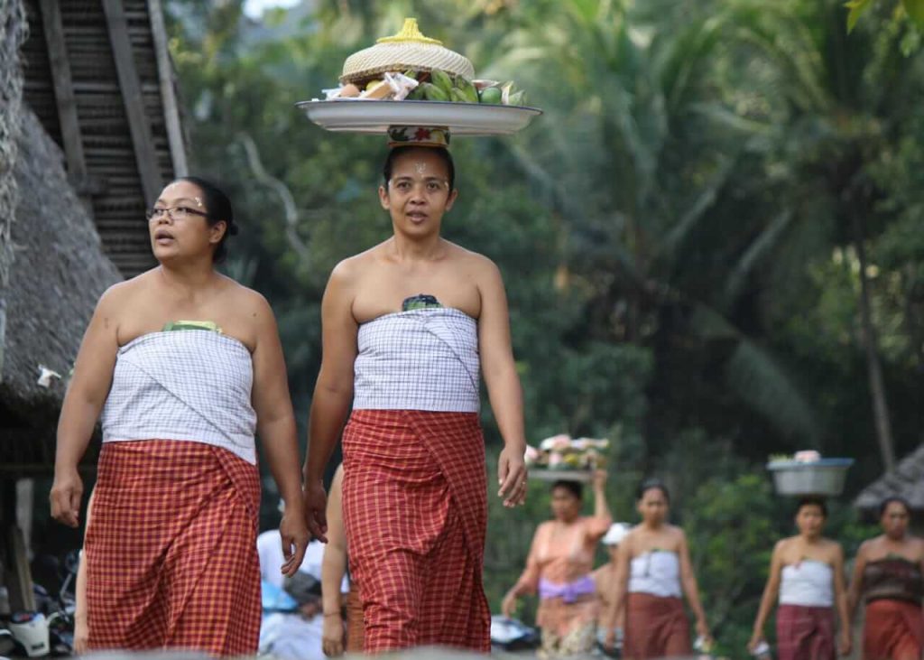 Perempuan Tenganan mengenakan pakaian adat sederhana berupa kain tradisional tanpa ornamen mewah.