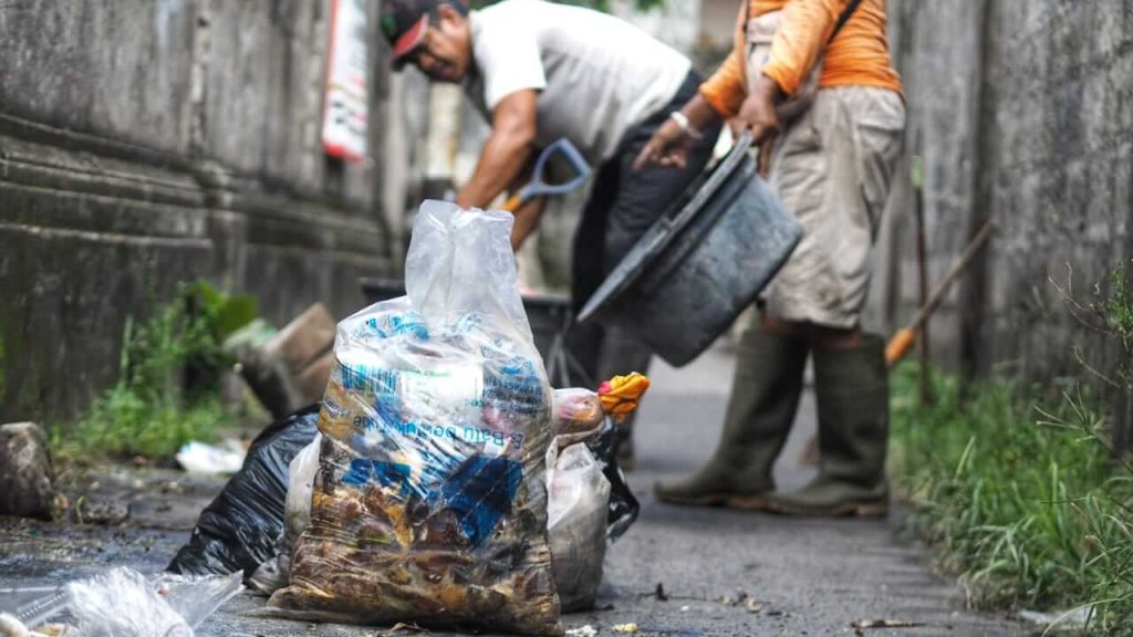Petugas kebersihan membersihkan tumpukan sampah di Jalan Gunung Patuha Monang-Maning.