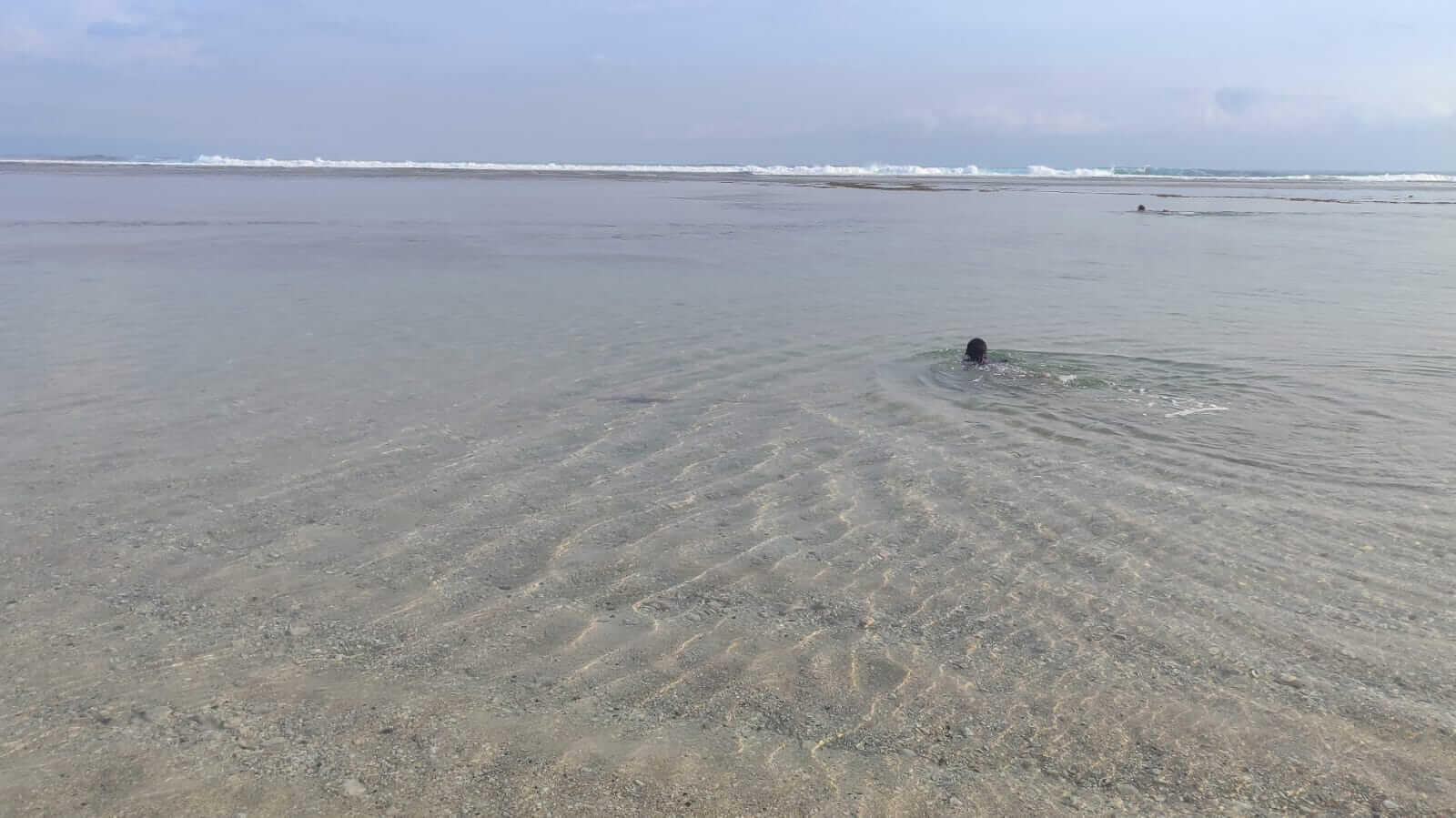 Air laut jernih di Pantai Timbis dengan dasar laut dangkal terlihat dari permukaan.