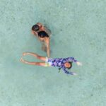 Hendra bermain bersama anak-anaknya di pantai dengan suasana ceria.