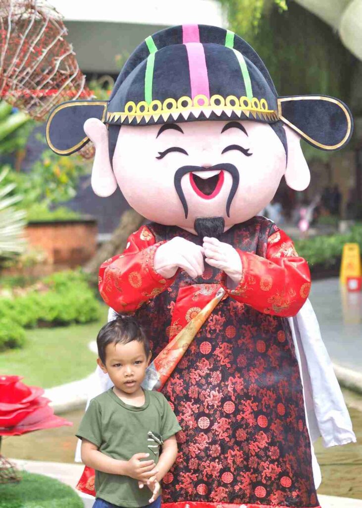 Maskot berpakaian tradisional Tionghoa menyambut pengunjung di Beachwalk Shopping Center.