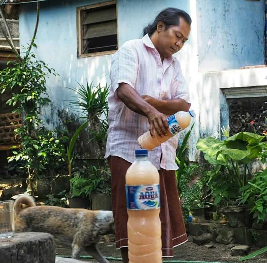 Minuman dituangkan ke tanah sebagai simbol penghormatan dan rasa syukur.