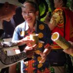 Penyuguhan tuak kepada tamu sebagai tradisi penyambutan di desa.