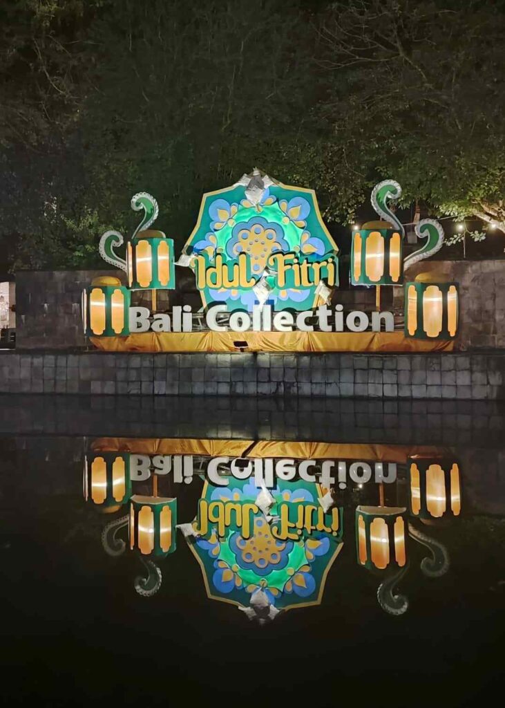 Lampu dekorasi bertuliskan Idul Fitri menyala di Bali Collection pada malam hari.