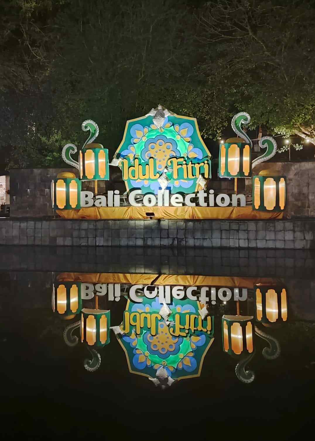 Lampu dekorasi bertuliskan Idul Fitri menyala di Bali Collection pada malam hari.