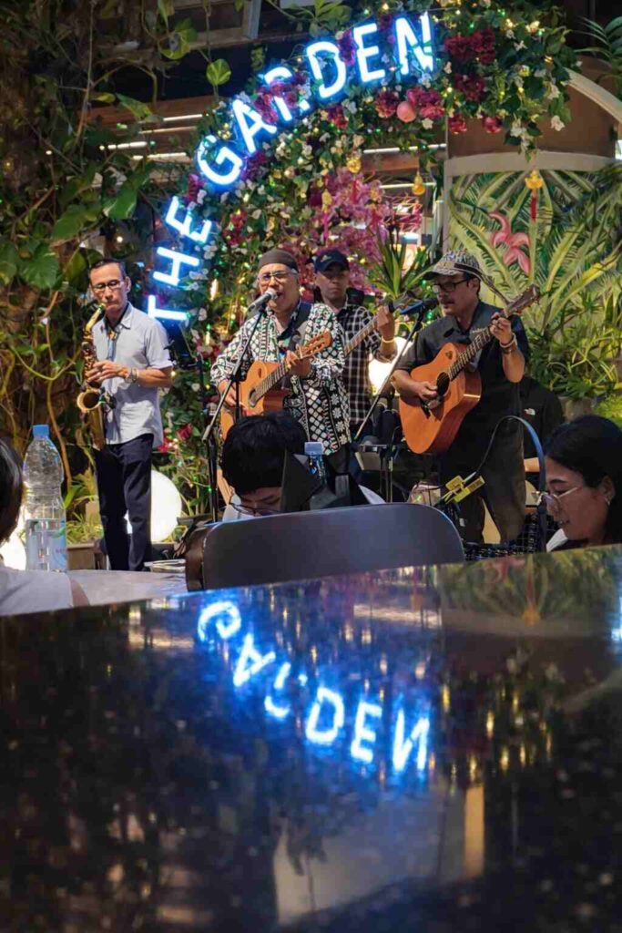 Suasana malam di The Garden dengan nuansa hangat dan pertunjukan musik.