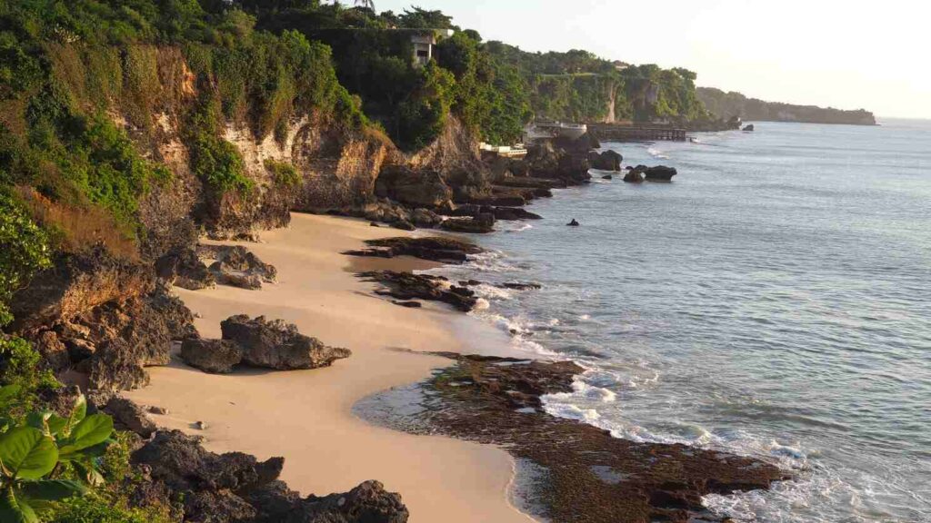 Pantai di Bali sebagai ruang spiritual dengan aktivitas tradisi dan doa masyarakat.