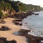 Pantai di Bali sebagai ruang spiritual dengan aktivitas tradisi dan doa masyarakat.