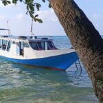 Perahu terdiam di perairan tenang, mencerminkan suasana hening dan reflektif.