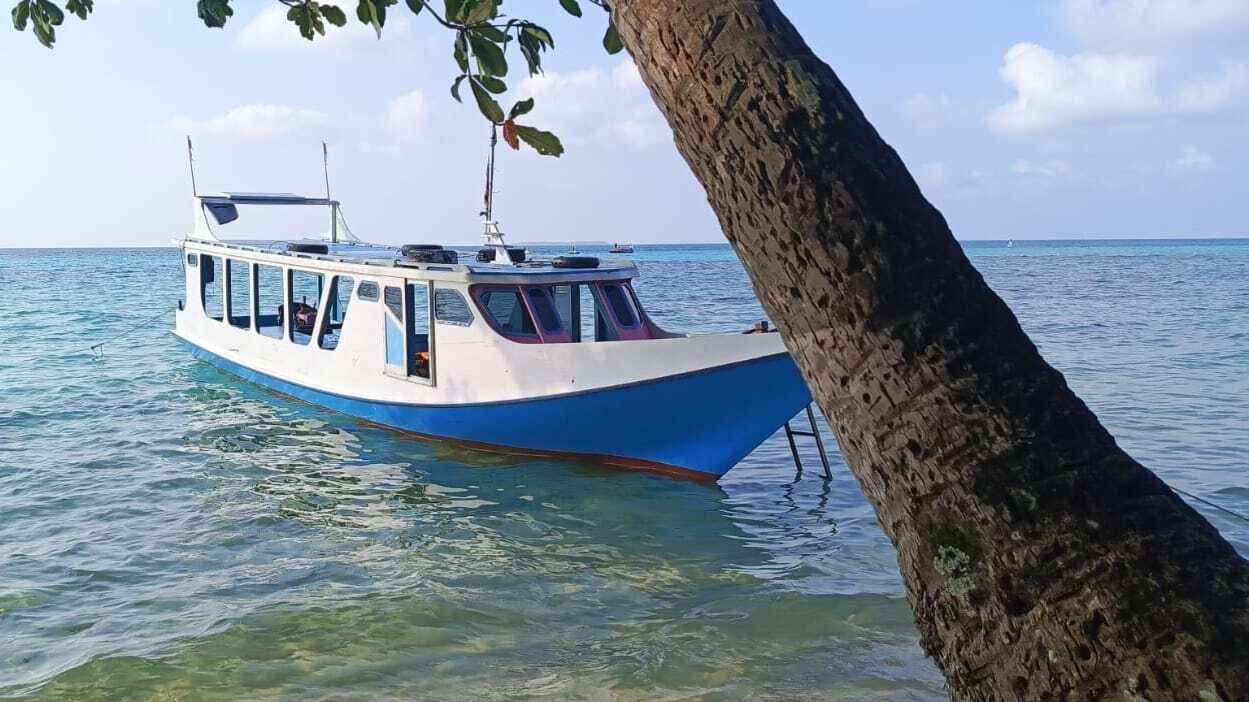 Perahu terdiam di perairan tenang, mencerminkan suasana hening dan reflektif.