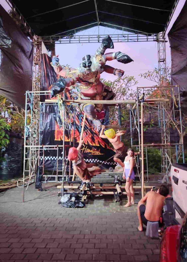 Dua wisatawan mancanegara memotret ogoh-ogoh dengan ponsel.