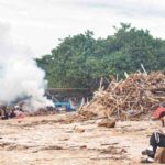 Warga membakar tumpukan sampah kayu dan bambu di pesisir Pantai Kedonganan.