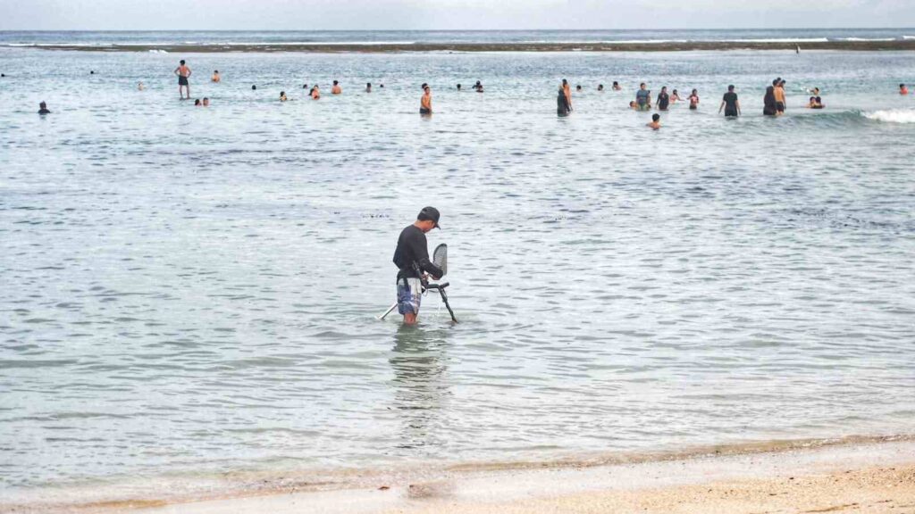 Seorang pemuda menunjukkan temuan emas dari hasil pencarian.
