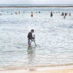 Seorang pemuda menunjukkan temuan emas dari hasil pencarian.