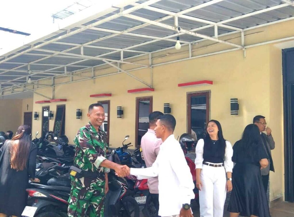 Babinsa berinteraksi dengan masyarakat dalam menjaga keamanan wilayah.