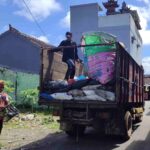 Petugas memilah sampah saat proses pengangkutan ke dalam truk di kawasan perumahan.