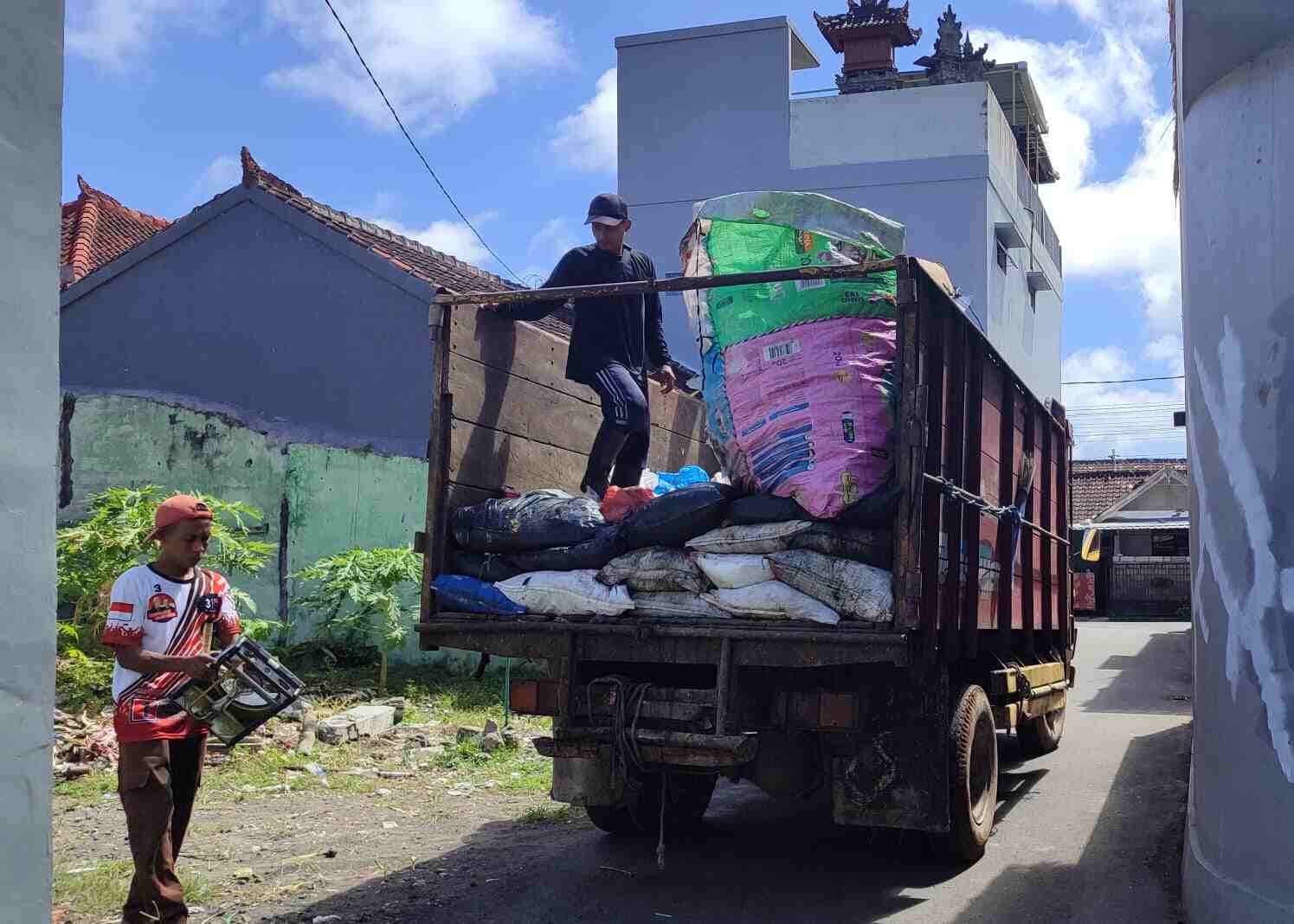 Petugas memilah sampah saat proses pengangkutan ke dalam truk di kawasan perumahan.