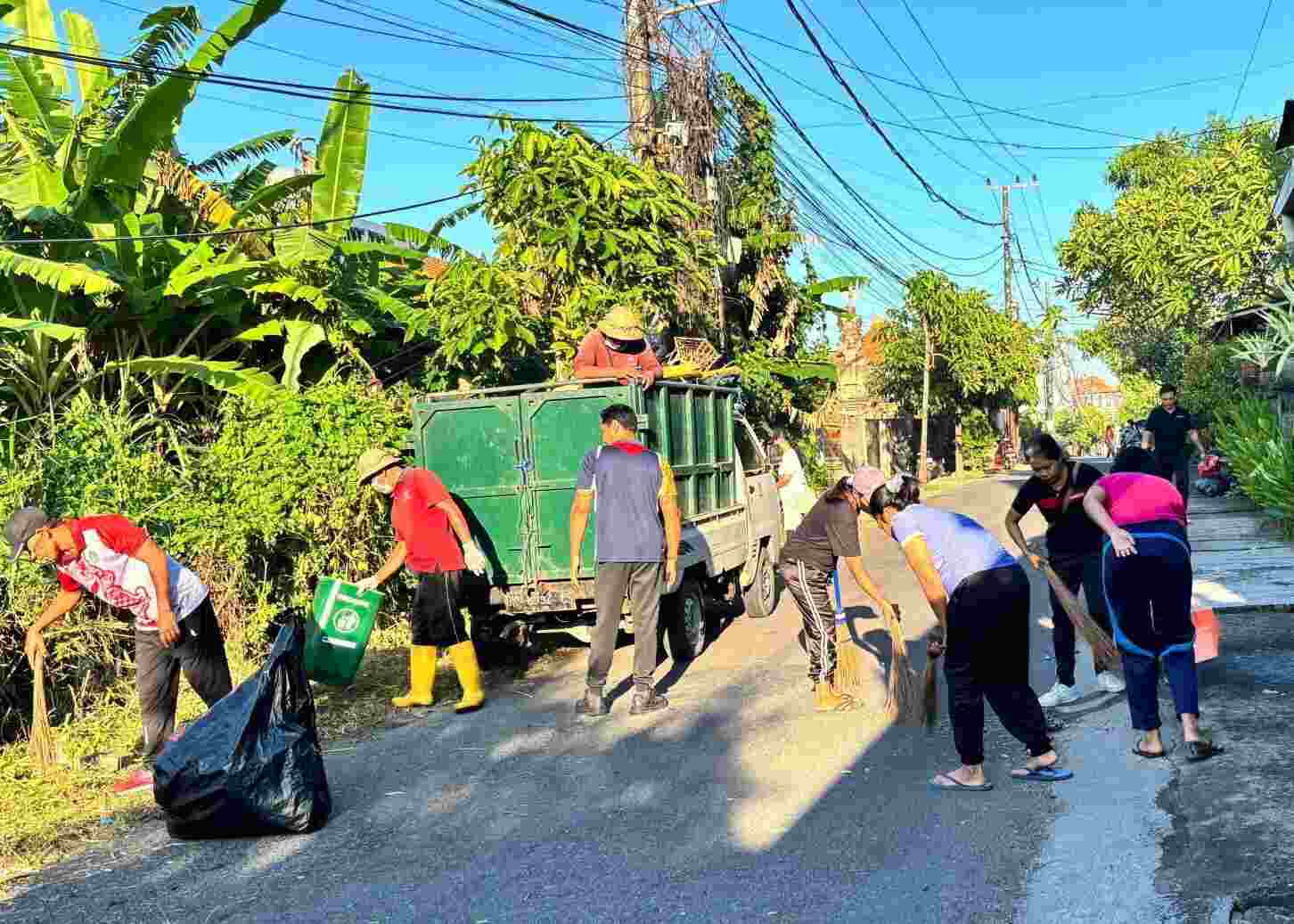 Warga bersama-sama melakukan kegiatan gotong royong di lingkungan dengan suasana kebersamaan