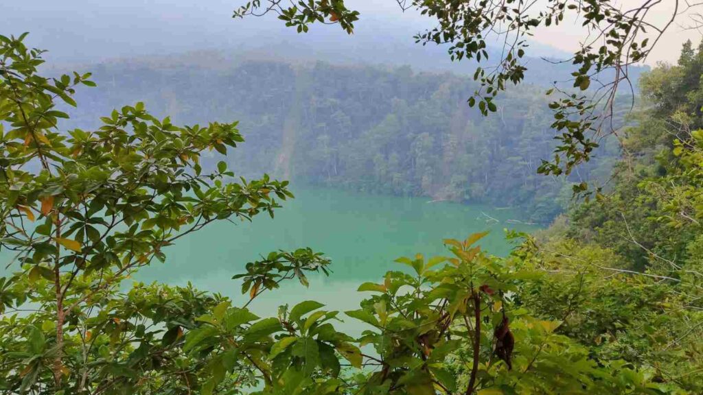 Danau Tolire dengan panorama alam yang tenang dikelilingi perbukitan hijau