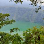 Danau Tolire dengan panorama alam yang tenang dikelilingi perbukitan hijau