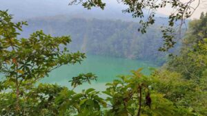 Danau Tolire dengan panorama alam yang tenang dikelilingi perbukitan hijau