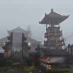 Kabut menyelimuti desa adat di pegunungan Bali dengan arsitektur tradisional dan suasana tenang