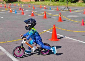 Seorang anak melaju di lintasan sederhana sebagai simbol keberanian dan proses belajar