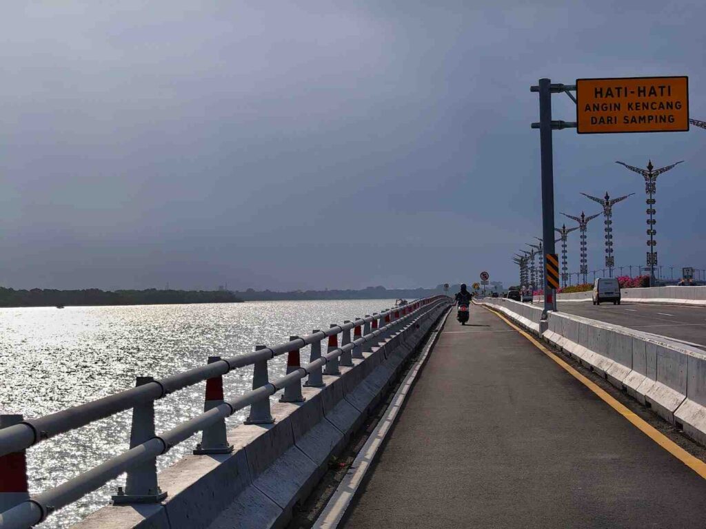 Pemandangan Jalan Tol Bali Mandara dengan perpaduan cahaya matahari dan langit mendung