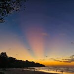 Pantai Bali saat senja dengan pemandangan laut dan langit berwarna hangat