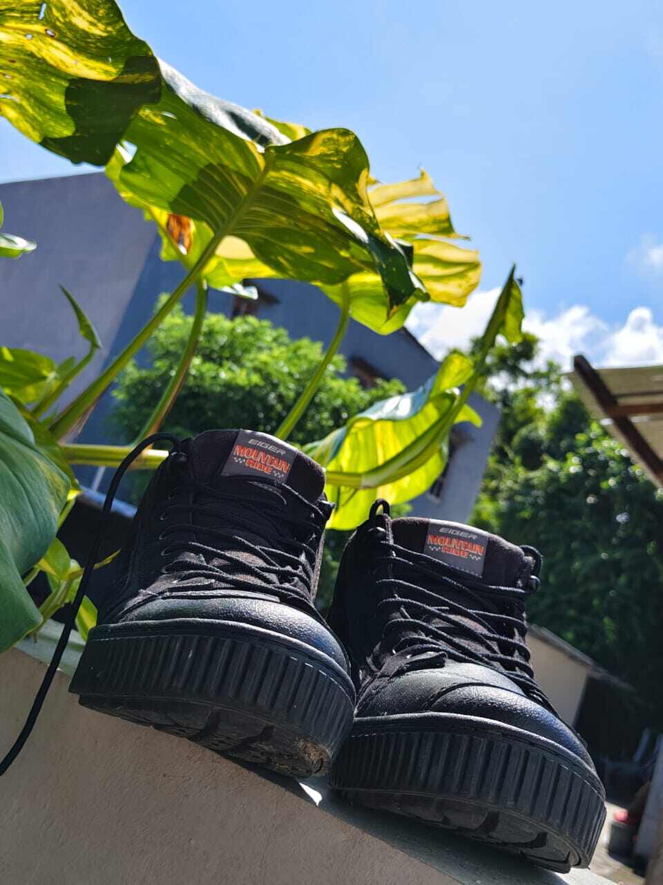 Sepasang sepatu hitam sederhana dengan suasana yang menggambarkan makna dan kenangan