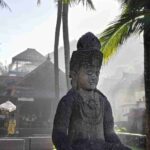 Suasana pagi di Candidasa dengan cahaya matahari terbit menyinari pepohonan dan bangunan