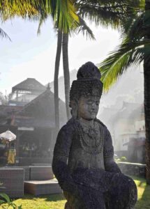 Suasana pagi di Candidasa dengan cahaya matahari terbit menyinari pepohonan dan bangunan