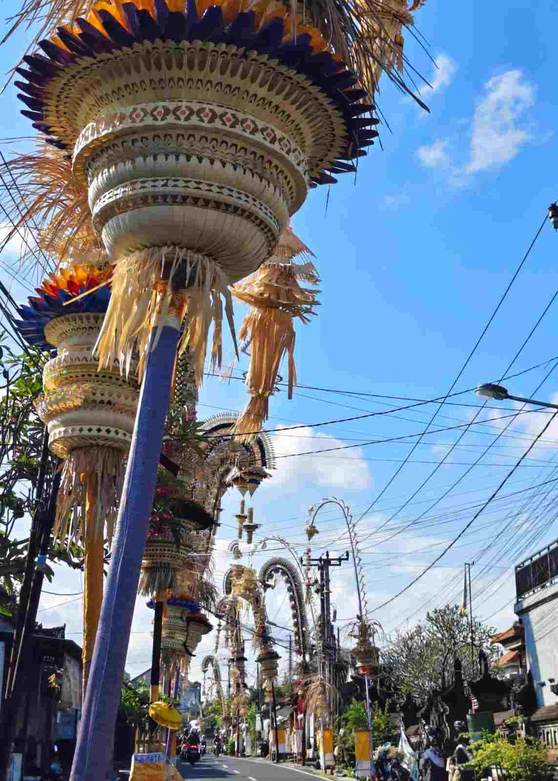 Penjor Bali dengan hiasan janur dan hasil bumi menghiasi jalan menjelang Galungan dan Kuningan