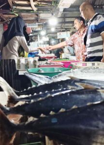 Wisatawan mancanegara bertransaksi dengan pedagang ikan di Pasar Ikan Kedonganan