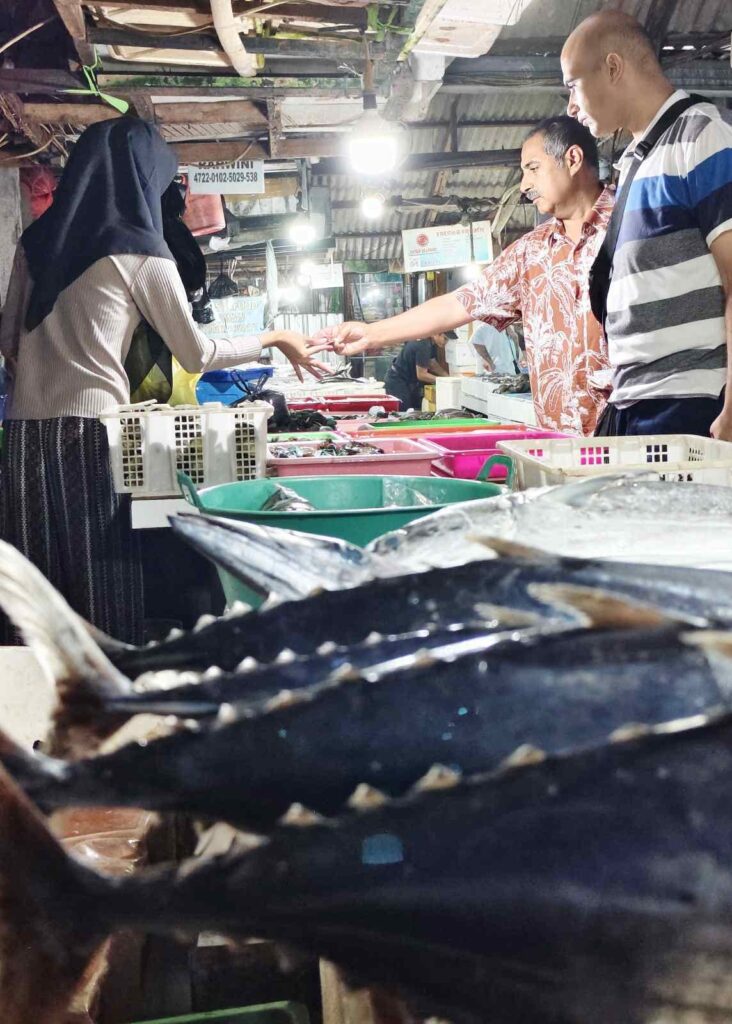Wisatawan mancanegara bertransaksi dengan pedagang ikan di Pasar Ikan Kedonganan