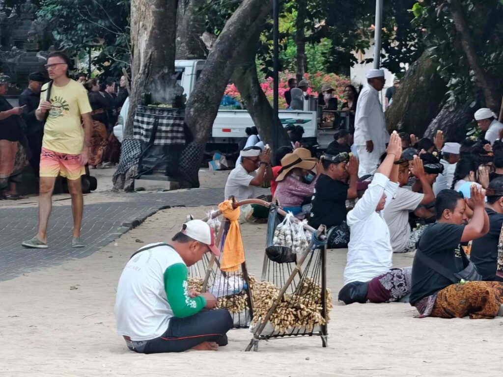 Umat berdoa sementara pedagang menunggu pembeli di sekitar lokasi ibadah